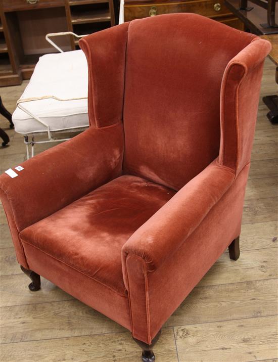 A red dralon upholstered wing armchair	